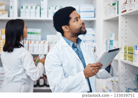 Pharmacy stock check, black man and tablet checklist of medicine and pills. Pharmacist, digital work and pharmaceutical products in a retail shop or clinic with healthcare and wellness employee 133039751