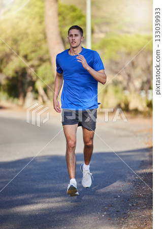 Fitness, running exercise and man on road for health, wellness and strength outdoors. Sports, training and young male athlete or runner workout, cardio jog or exercising for endurance and energy. 133039933