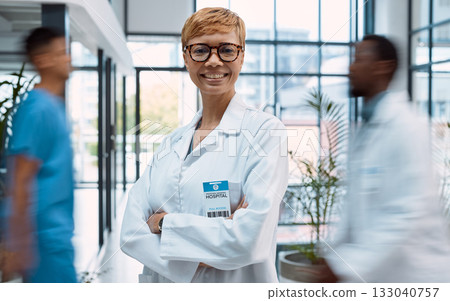 Portrait, healthcare and motion blur with a doctor black woman standing arms crossed in a busy hospital. Medical, insurance and trust with a female medicine professional in a clinic for treatment 133040757