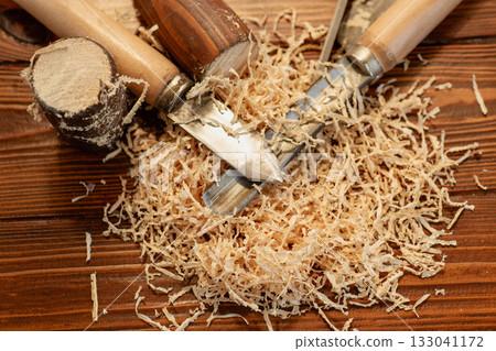 Close up of wood carving with sawdust on wooden table Close up of wood carving with sawdust on wooden table 133041172