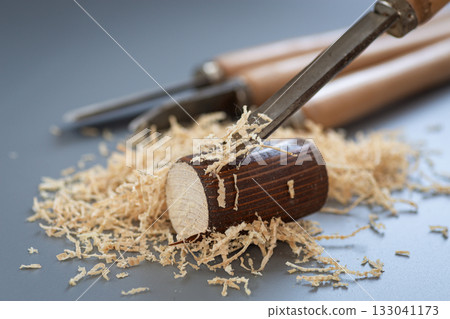 Shavings and wooden mallet on gray background Shavings and wooden mallet on gray background 133041173