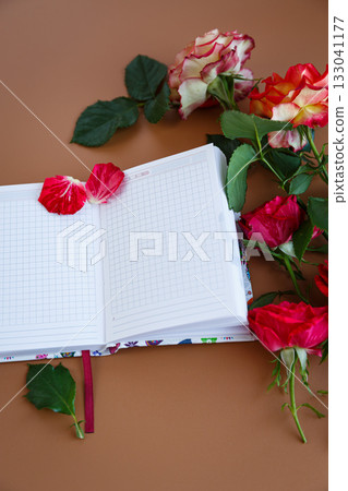 Notes over a cup of cappuccino among fresh rose petals 133041177