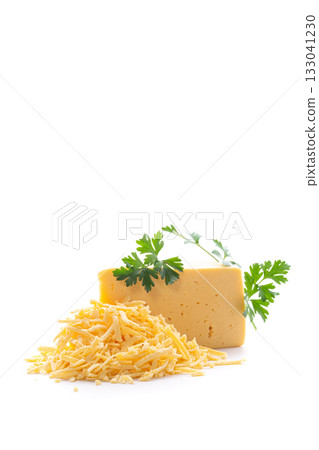 Fresh yellow cheese with grated pieces and green garnish 133041230