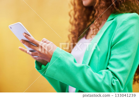 Woman, phone and hands typing on yellow background for communication, social media and tech chat. Closeup model, smartphone and network connection for mobile app, digital contact and search website 133041239