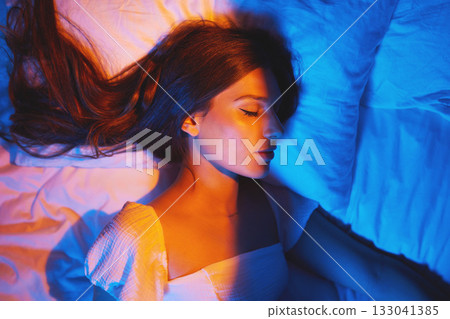 Sleeping beauty, lights and woman with sleep and creative neon lighting. Resting, face and model glow and feeling relax and calm on a bed pillow with aesthetic profile in a bedroom bed at home Sleeping beauty, lights and woman with sleep and creative neon lighting. Resting, face and model glow and feeling relax and calm on a bed pillow with aesthetic profile in a bedroom bed at home 133041385