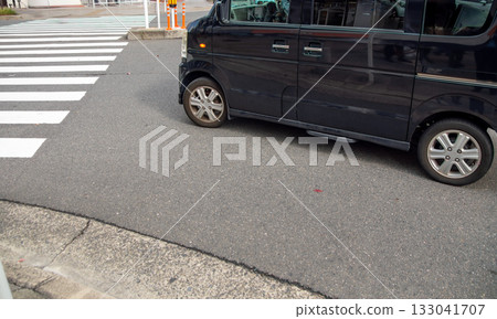 一輛左轉的汽車在人行道前停了下來。 一輛左轉的汽車在人行道前停了下來。 133041707