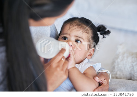 Baby drink bottle, formula and nutrition with feeding and family, healthy and growth with early childhood development. Mother feed infant child milk, people at home with health and wellness 133041786