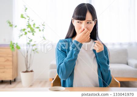Young woman pinching her nose 133041970