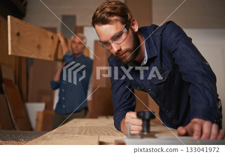 Carpentry collaboration, carpenter and men work in workshop on design project with vocation and creative skill. Teamwork, male worker cutting wood with power tools and father and son working together 133041972
