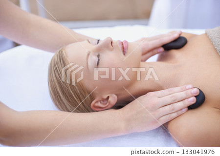 Woman getting hot stone massage, hands of masseuse in spa and healing holistic treatment with zen at wellness resort. Rocks on shoulders, peace with therapy, alternative medicine and self care Woman getting hot stone massage, hands of masseuse in spa and healing holistic treatment with zen at wellness resort. Rocks on shoulders, peace with therapy, alternative medicine and self care 133041976