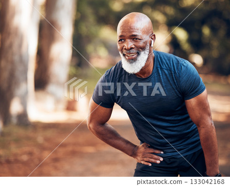 Black man, break from running and relax with fitness, vitality and cardio, senior runner in the park. Exercise, earpods and listen to music for motivation, tired with endurance and health outdoor 133042168