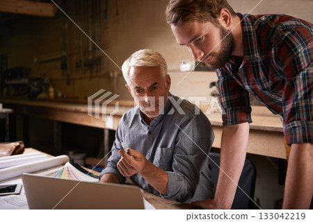 Architects, teamwork and father and son with laptop in workshop for building construction. Senior engineer, men and computer with trainee or apprentice working on design and planning with mentor. Architects, teamwork and father and son with laptop in workshop for building construction. Senior engineer, men and computer with trainee or apprentice working on design and planning with mentor. 133042219