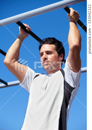 Man, fitness and pull ups on monkey bars in nature, park or outdoor gym for weightlifting, exercise or workout. Fit, active and strong male lifting body weight or hanging on iron bar for exercising Man, fitness and pull ups on monkey bars in nature, park or outdoor gym for weightlifting, exercise or workout. Fit, active and strong male lifting body weight or hanging on iron bar for exercising 133042321