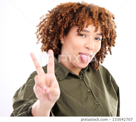 Tongue out, peace sign and portrait of a young black woman with funny hand sign in studio. Isolated, white background and gen z pose for social media with happiness and silly and funny hands gesture 133042707