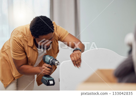 DIY, drill and crib with a black man in his house to build furniture in the baby bedroom or nursery. Family home, handyman and cot with a father in a room building a bed for his newborn kid DIY, drill and crib with a black man in his house to build furniture in the baby bedroom or nursery. Family home, handyman and cot with a father in a room building a bed for his newborn kid 133042835
