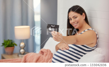 Pregnant, woman portrait and ultrasound in hand for baby development or growth. Happy person show fetus scan photograph in bed for gynecology, pregnancy update and health or wellness in home bedroom Pregnant, woman portrait and ultrasound in hand for baby development or growth. Happy person show fetus scan photograph in bed for gynecology, pregnancy update and health or wellness in home bedroom 133042836