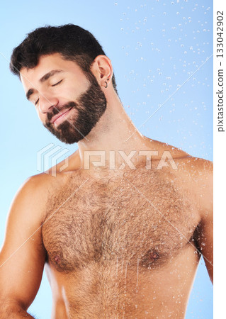Body care, relax and man in studio for skincare, grooming and hygiene against blue background. Luxury, bathroom and guy model happy in shower, smile and isolated on water splash, cosmetic or wellness Body care, relax and man in studio for skincare, grooming and hygiene against blue background. Luxury, bathroom and guy model happy in shower, smile and isolated on water splash, cosmetic or wellness 133042902