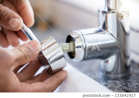 Plumber, hands and faucet, plumbing and maintenance with man, manual labour closeup and home renovation. Construction trade, handyman with kitchen or bathroom sink with hardware, pipe and DIY 133042917