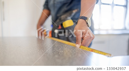 Carpenter, work table and measure tape with hands, design diy and home improvement for building, wood or job. Builder, construction worker and handyman by countertop, planning and vision in workplace Carpenter, work table and measure tape with hands, design diy and home improvement for building, wood or job. Builder, construction worker and handyman by countertop, planning and vision in workplace 133042937