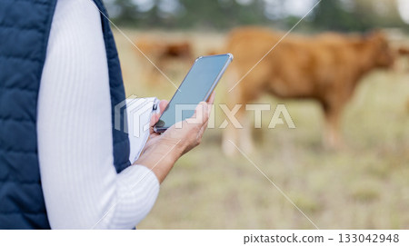 Hands, phone or veterinarian on farm to check cattle livestock wellness or animals natural environment. Website, internet data or person reading news or networking online to protect cows healthcare Hands, phone or veterinarian on farm to check cattle livestock wellness or animals natural environment. Website, internet data or person reading news or networking online to protect cows healthcare 133042948