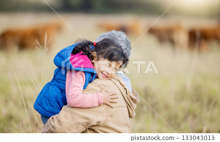 Grandmother, happy hug and girl on nature walk with senior woman in the countryside. Outdoor field, grass and elderly female with child on a family adventure on vacation with happiness and fun 133043013