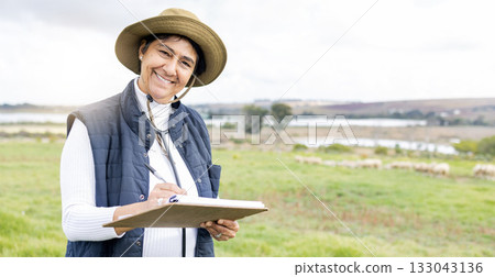 Clipboard, farmer and portrait of a woman on a farm with checklist to monitor growth and development. Happy, smile and mature female working on sustainable, agriculture and agro field in countryside. 133043136