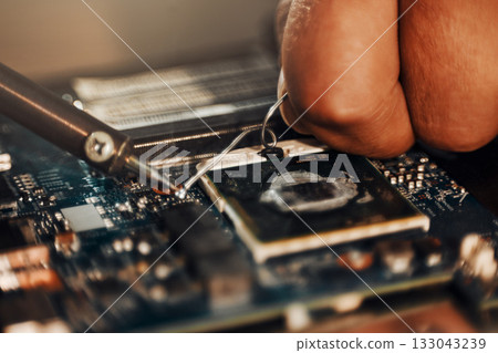 Hands, motherboard soldering and man repair hardware circuit, electronics or semiconductor. CPU system maintenance, service industry closeup or information technology worker fix microchip in tech lab 133043239