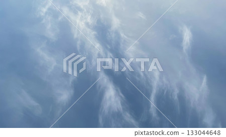 Soft, wispy cirrus clouds in a vast blue sky. Ideal for a serene nature background or texture 133044648