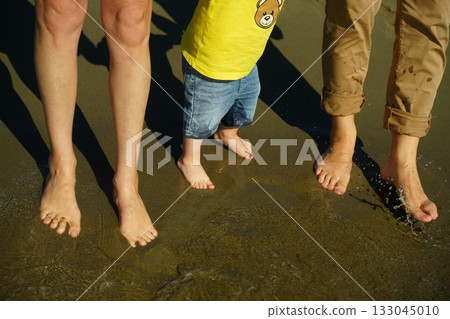 Family Enjoying Barefoot Walk on Sandy Beach Family Enjoying Barefoot Walk on Sandy Beach 133045010