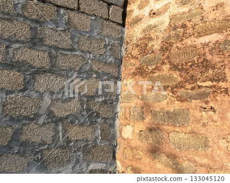 Ancient heritage wall standing next to newly constructed block wall symbolizing mix of preservation and modern development Ancient heritage wall standing next to newly constructed block wall symbolizing mix of preservation and modern development 133045120