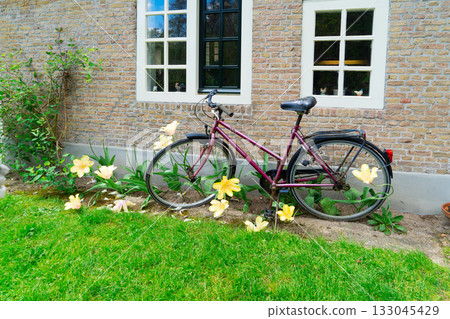 Old bicycle next to canal of Amsterdam 133045429