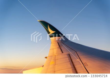 Wing of a Cathay Pacific A350 flying over a sunset and sea of clouds Wing of a Cathay Pacific A350 flying over a sunset and sea of clouds 133045714