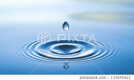 Water drop falling. Drop of water falling into a rippled surface of water 133045822