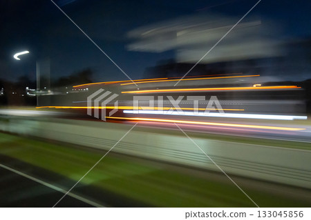 Light trails of a moving vehicle at night on the road 133045856