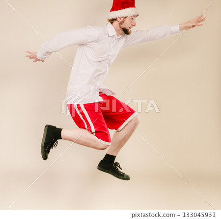 Active man in santa hat dancing and jumping. Active man in santa hat dancing and jumping. 133045931