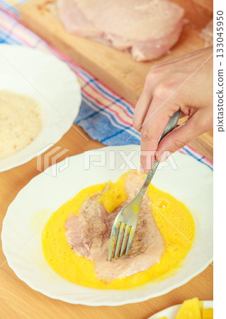 Preparing meal of breaded chicken cutlets Preparing meal of breaded chicken cutlets 133045950