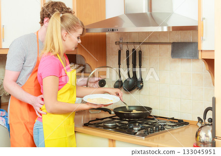 Couple woman and man frying breaded chicken cutlet Couple woman and man frying breaded chicken cutlet 133045951