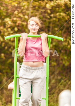 Active woman exercising at outdoor gym. 133045961