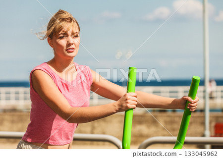 Active woman exercising on elliptical trainer. Active woman exercising on elliptical trainer. 133045962