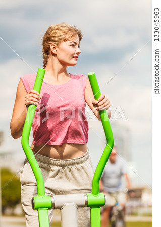 Active woman exercising on elliptical trainer. 133045963