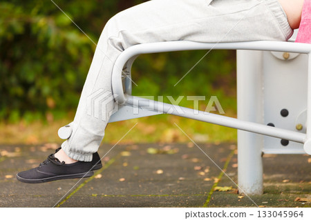 Active woman exercising on bench outdoor. 133045964