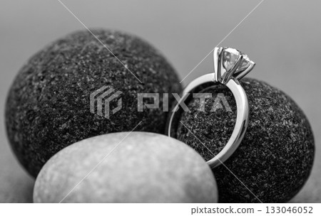 A diamond ring is placed on top of a rock A diamond ring is placed on top of a rock 133046052
