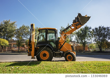 A yellow construction vehicle with a large bucket on the back A yellow construction vehicle with a large bucket on the back 133046069