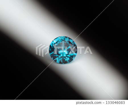 A blue diamond is sitting on a white surface 133046083
