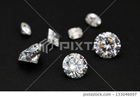 A collection of diamonds and other gemstones are displayed on a black background 133046097