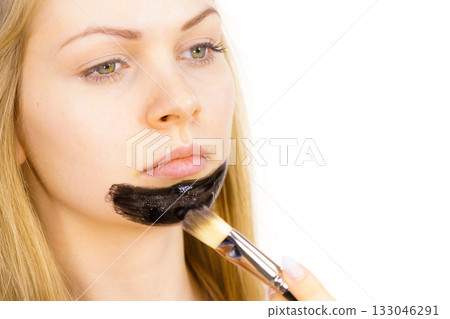 Girl being apply carbo mask to skin face 133046291