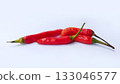 A bunch of bright red chilies with green stems arranged on a white background 133046577