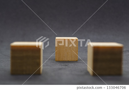 An isolated wooden cube on black cover background with customizable space for text or ideas. Copy space concept An isolated wooden cube on black cover background with customizable space for text or ideas. Copy space concept 133046706
