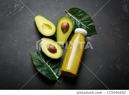 Avocado smoothie fresh fruit halves dark background healthy drink diet nutrition 133046892