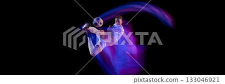 Soccer player performing overhead kick with dynamic neon trail on black background. Banner Soccer player performing overhead kick with dynamic neon trail on black background. Banner 133046921